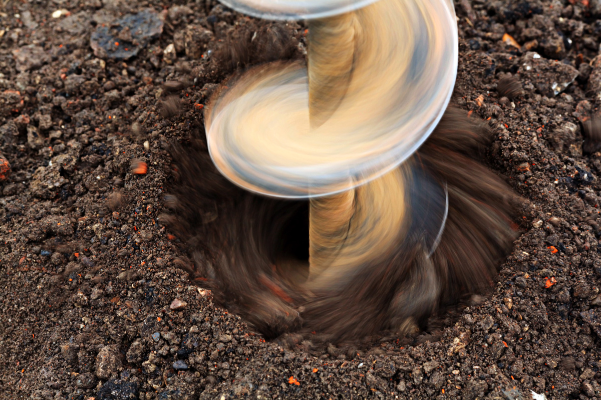 A close-up image of a drilling machine drilling a hole into the dirt in El Paso.